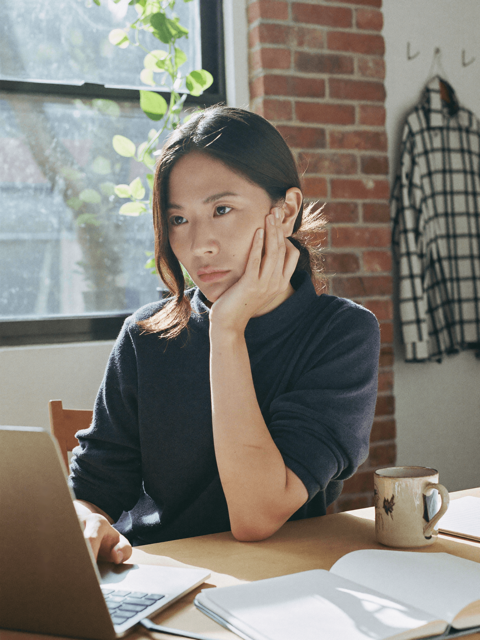 ノートPCに向き合い、一人で考え込む女性