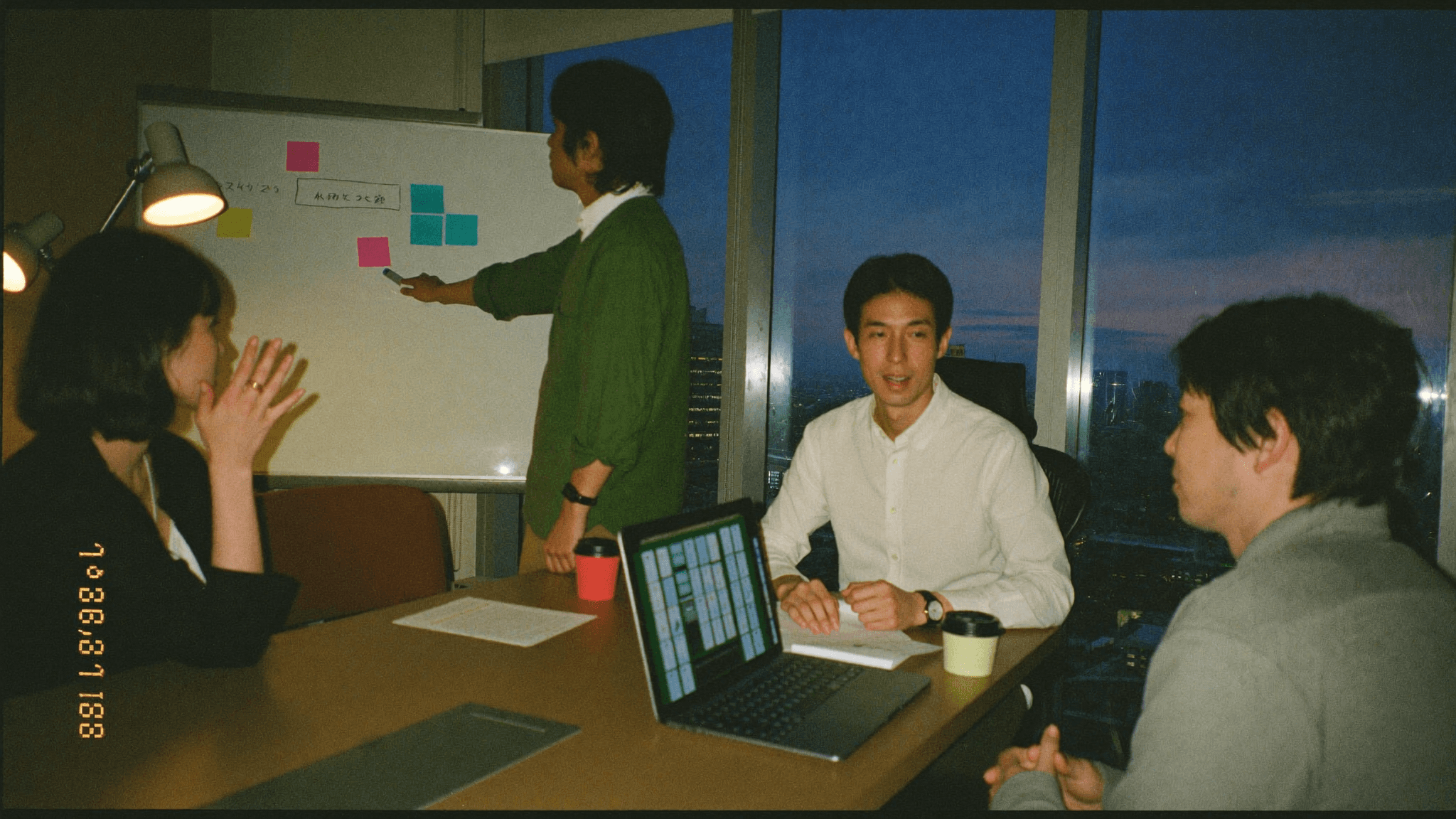 グラフ資料に赤ペンで印を付けながら改善点を検討する二人